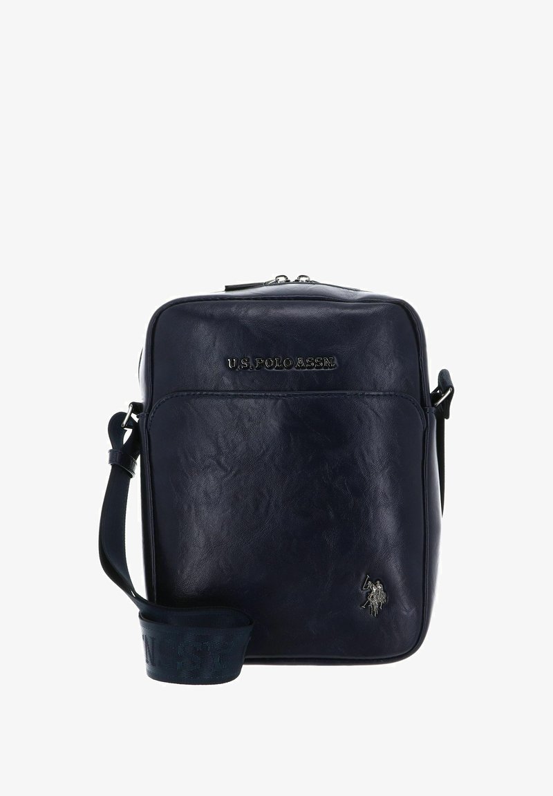 Sac bandoulière en cuir bleu marine avec finition texturée, fermeture éclair, sangle ajustable et logo en relief sur le devant. Comprend un petit accent de logo.
