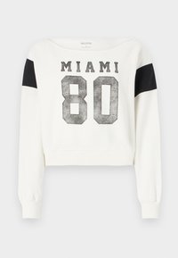 Balta trumpa sportinė palaidinė su juodais peties akcentais. Priekyje spausdinta „MIAMI 80“ nusidėvėjusiu stiliumi. Minkšta medžiaga, ilgos rankovės.