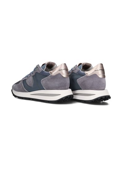 Grijze en marineblauwe sneakers van suede en mesh, met een metallic zilveren hielaccent en een witte tussenzool met een gestructureerde zwarte buitenzool.
