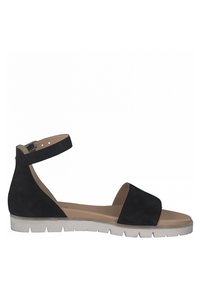 Sandale plate noire avec bride à la cheville, bout ouvert, semelle intérieure rembourrée beige et semelle en caoutchouc blanc nervuré.