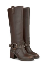 Botas de cuero marrón hasta la rodilla con un tacón grueso, que presentan una correa decorativa con herrajes metálicos y tachuelas. Textura suave y forma estructurada.
