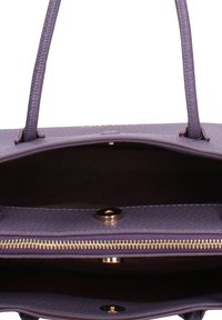 Borsa a mano viola con texture, dotata di due manici, chiusura con zip e interno liscio con un dettaglio decorativo in oro e chiusura a bottone.