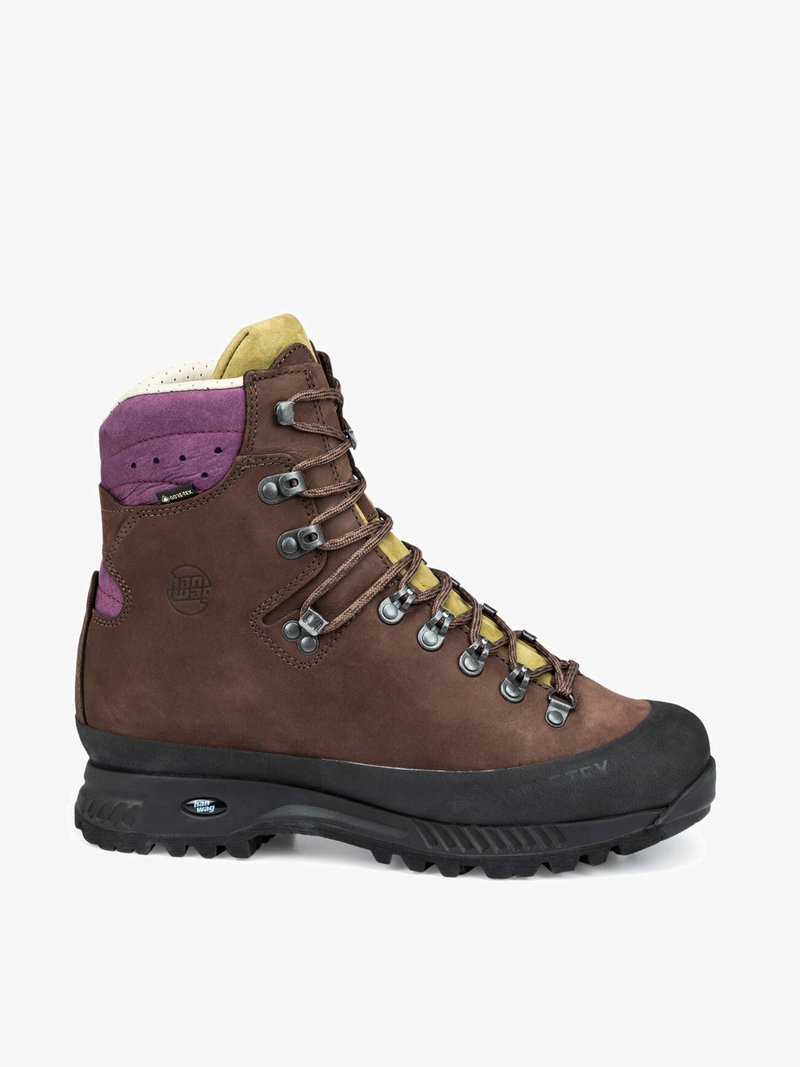 Bota de hiking em couro castanho com sola de borracha, detalhes em roxo e amarelo, ilhós de metal e colarinho acolchoado. Forro impermeável em Gore-Tex.