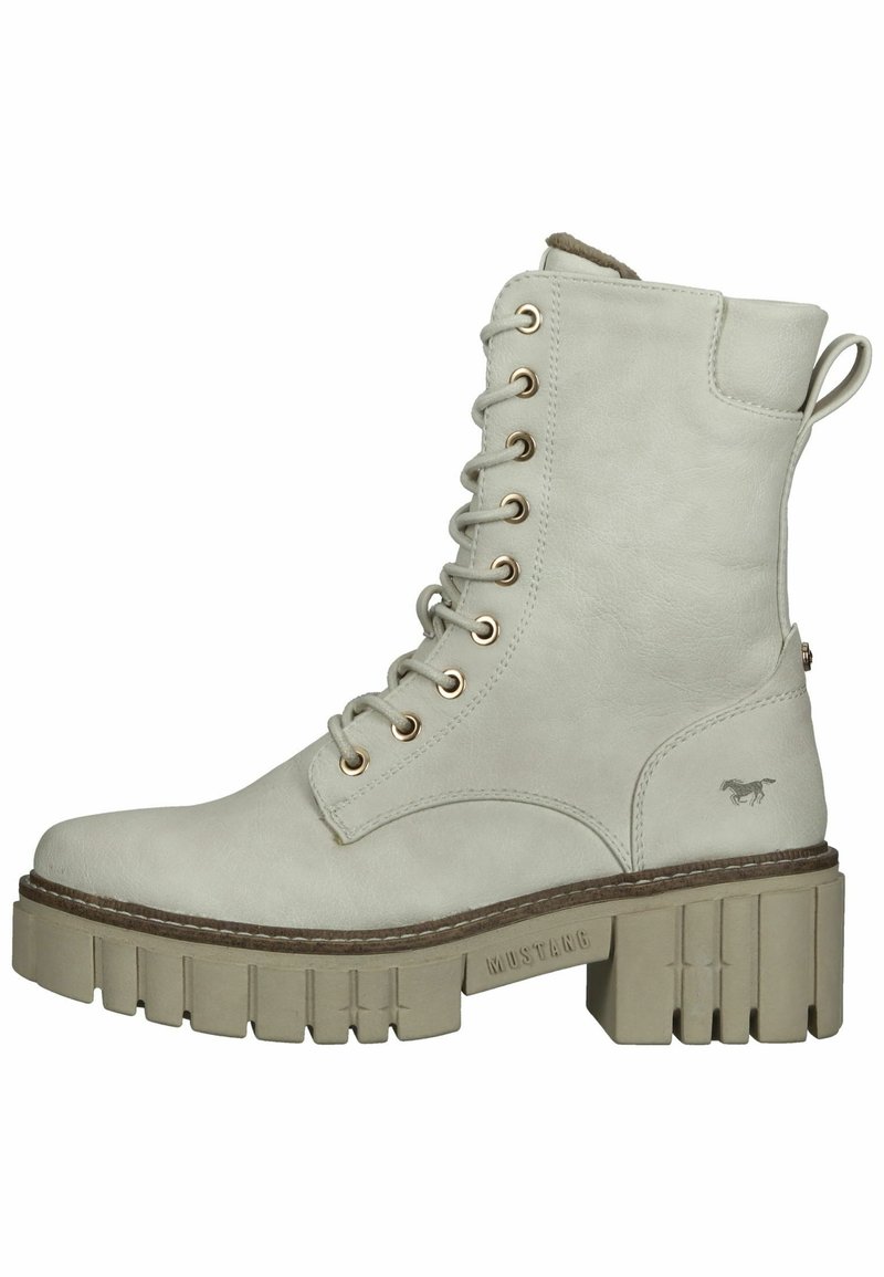 Botín de tobillo con cordones en material sintético de color gris claro, con una suela gruesa de diseño estriado y ojales dorados. Pequeño logotipo en el costado.