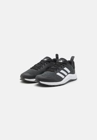 Black athletic shoes with a textured fabric upper, white three-stripe design, padded collar, and rubber outsole with a patterned tread.