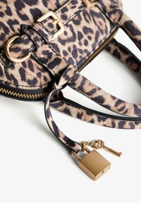 Borsa con stampa leopardata, dettagli in pelle sintetica nera, fibbie dorate, chiusura con zip e un dettaglio decorativo di lucchetto e chiave.