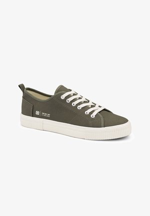 Olijfgroene canvas sneaker met witte rubberen zool en veters, met een lus aan de achterkant en tekstdetails aan de zijkant.