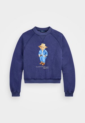 Námornícky modrá mikina s okrúhlym výstrihom a raglánovými rukávmi. Na prednej strane je obrázok medveďa oblečeného v džínsovinovom oblečení a text "POLO BEAR od RALPH LAUREN."