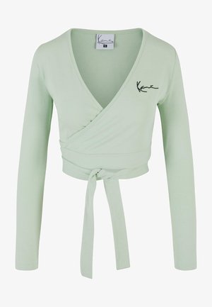 Svijetlozeleni wrap top s dugim rukavima. Ima duboki V-izrez, vezivanje u struku i izvezeni logo. Napravljen od mekane, rastezljive tkanine.