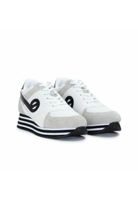 Grijze en witte sport schoenen met een bovenwerk van Suède en mesh, voorzien van een zwart accent, gestreepte zool en geperforeerde details op de teen.