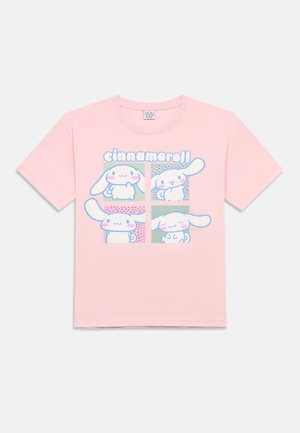 T-shirt rosa con quattro illustrazioni di personaggi Cinnamoroll in colori pastello, ognuno con diverse espressioni, e la parola "cinnamoroll" sopra.