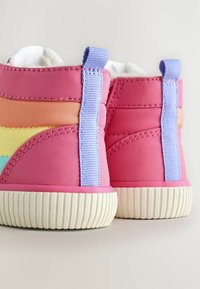 Rosa Kinderstiefel mit einer glatten, strukturierten Oberfläche. Kontrastierende Pastellstreifen in Orange, Gelb und Blau. Weiße Gummisohlen.