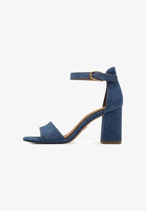 Sandalo con tacco a blocco in denim blu, punta aperta e cinturino alla caviglia con fibbia dorata, isolato su sfondo bianco.