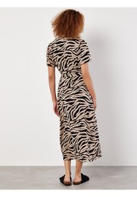 Maxi-Kleid in Beige mit schwarzen Zebramustern. Kurze Ärmel, tailliert, schwingende Silhouette und ein gerader Saum, der bis zur Mitte der Wade reicht.