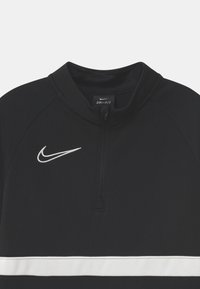 Pullover Nike DRI-FIT nero con colletto a mezza zip, caratterizzato da una striscia bianca che attraversa il petto e un logo ricamato bianco a sinistra.