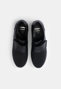 Chaussures noires à enfiler avec un design en maille texturée à l'avant, des accents en cuir lisse et une ouverture rembourrée pour un confort optimal.