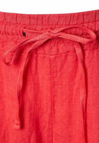 Pantaloni di lino rossi con vita regolabile tramite cordoncino, texture liscia e tessuto leggero per una buona traspirabilità.