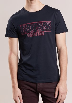 Marineblaues Baumwoll-T-Shirt mit Rundhalsausschnitt, auf der Brust auffällig mit rotem Schriftzug "BOSS ORANGE" bedruckt. Kurzärmlig und in regulärer Passform.