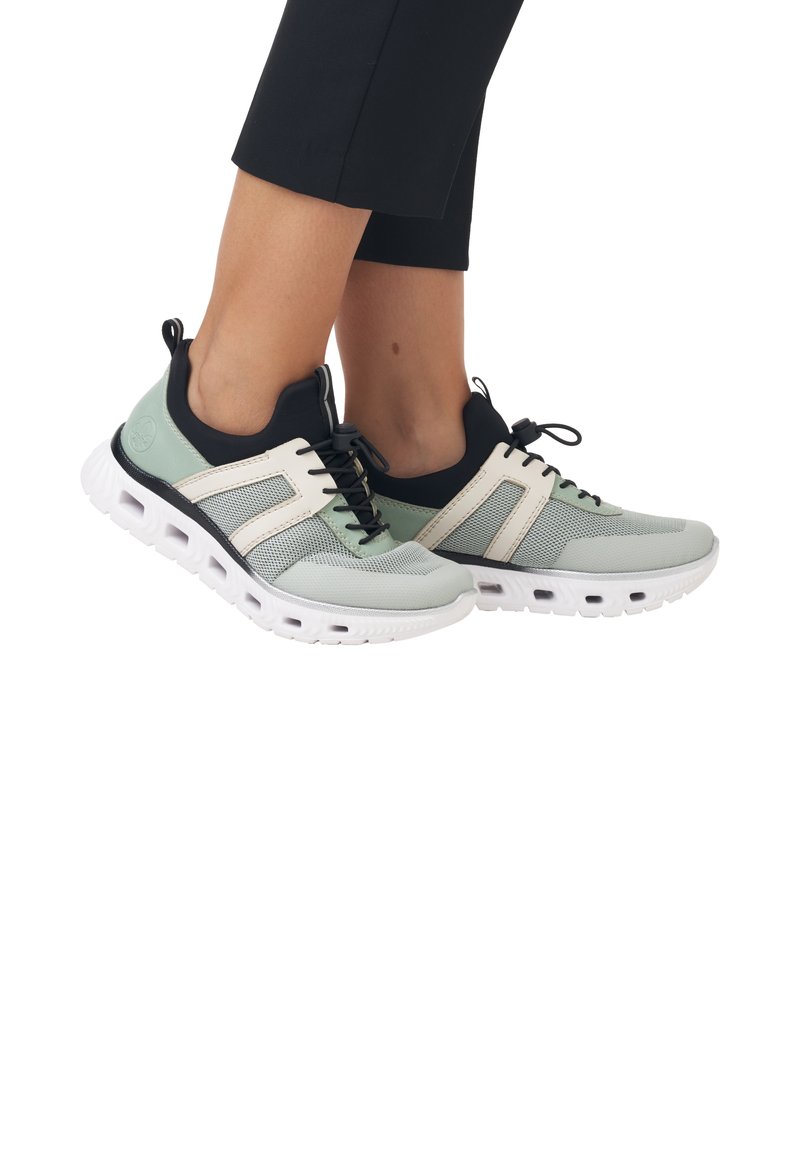 Baskets légères de sport avec une tige en mesh vert menthe et noir, une semelle intermédiaire blanche et un système de laçage proéminent avec des rayures latérales.