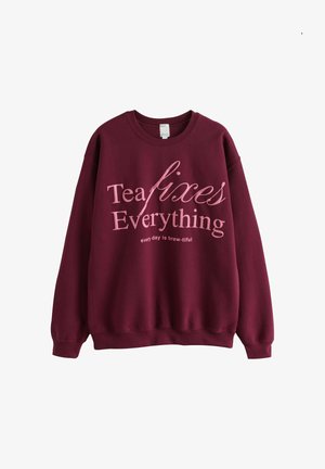 Bordeauxroter Pullover mit rosa Schriftzug „Tea fixes Everything“ und kleinerem Text „every day is brew-tiful“ auf der Vorderseite.