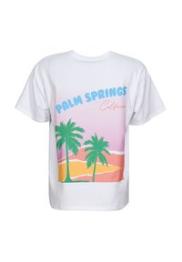 Camiseta blanca con un gráfico colorido de palmeras verdes contra colinas rosas y naranjas, y el texto "Palm Springs California" en azul y naranja.