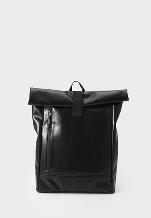 Schwarzer Rolltop-Rucksack mit vorderer vertikaler Reißverschlusstasche und oben liegendem Tragegriff vor schlichtem hellem Hintergrund.