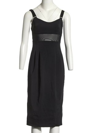 Robe midi noire sans manches avec de larges bretelles et un panneau horizontal transparent sous la poitrine, exposée sur un mannequin blanc.