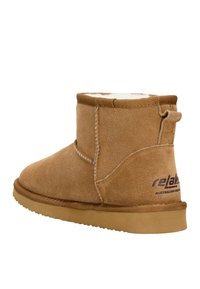 Braune Wildleder-Ankle Boots mit einem weichen weißen Fleece-Futter, runder Zehenform, Zuglasche hinten und einer sandfarbenen Gummisohle mit dunkler Branding.