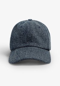 Gorra de denim en azul oscuro con un tejido texturizado, ala curvada y un detalle bordado de calavera y huesos cruzados en la parte delantera.
