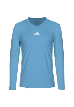 Lichtblauw sportshirt met lange mouwen en V-hals, met een wit Adidas-logo gecentreerd op de borst tegen een witte achtergrond.