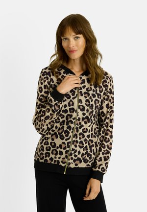 Sudadera con cremallera de estampado de leopardo en beige y negro, con capucha negra en contraste, puños acanalados y una cremallera dorada. Textura suave.