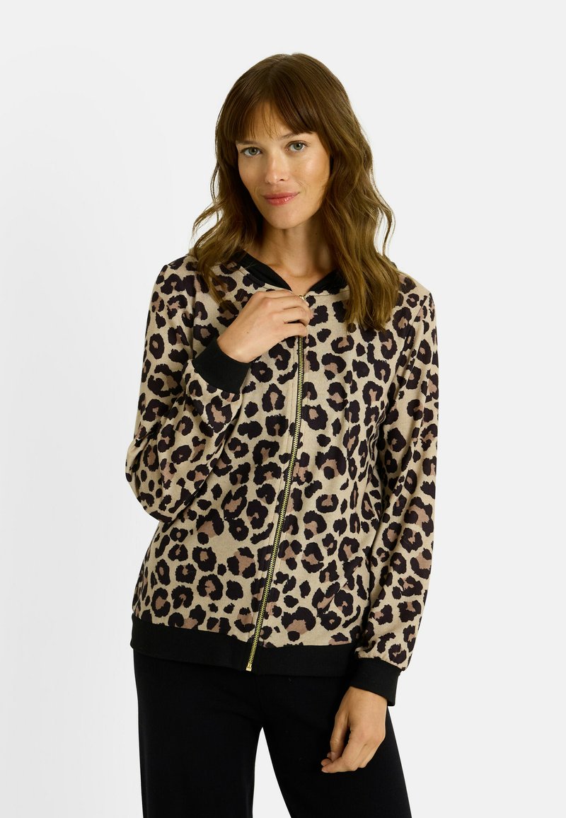 Sudadera con cremallera de estampado de leopardo en beige y negro, con capucha negra en contraste, puños acanalados y una cremallera dorada. Textura suave.