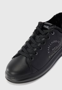 Fekete bőr sneaker fekete fűzőkkel, prém béléssel és "KARL LAGERFELD PARIS" felirattal az oldalon.