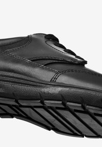 Chaussure en cuir noir avec dessus texturé, couture soignée et lacets noirs. Semelle en caoutchouc crantée pour une bonne adhérence et durabilité.