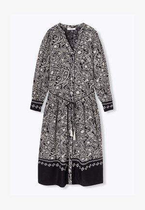 Robe à motifs paisley noir et blanc avec des manches longues, un col en V, une taille à cordon et un ourlet noir uni avec des accents floraux.