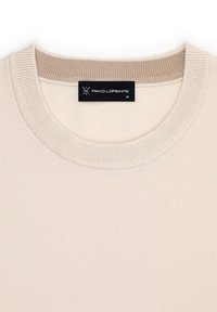 Beżowy sweter z prążkowanym okrągłym dekoltem, wykonany z gładkiej dzianiny. Posiada czarną metkę z logo umieszczoną przy dekolcie.