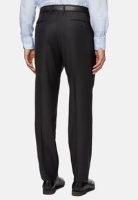 Černé kalhoty na míru se střihovým designem rovné nohavice, vyrobené z hladké tkaniny. Mají plochý přední díl, poutka na opasek a jednou zadní kapsu.