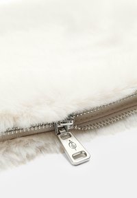 Krzna torbicu u boji off-white, s metalnim zatvaranjem i detaljnim šavovima. Mekana tekstura i elegantan, pravokutni oblik.