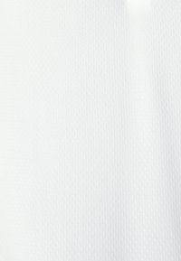 Tessuto a rete bianco con una superficie texturizzata, caratterizzato da piccoli fori distribuiti uniformemente per traspirabilità e leggerezza. Ideale per l'abbigliamento sportivo.