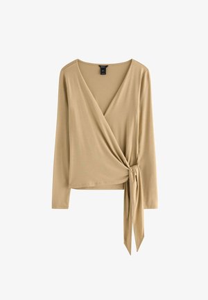 Beige langærmet slå-om-bluse med V-udskæring og bindebånd ved taljen. Lavet af et glat, elastisk stof. Enkel og ren design.