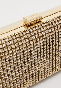 Gold clutch bag featuring a sparkling crystal-embellished surface, square shape, and a gold clasp closure with a smooth texture.