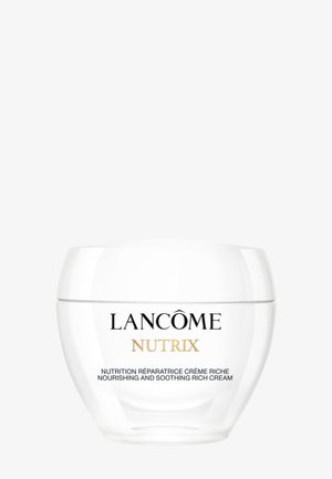 Lancôme Nutrix nærende og beroligende rig creme i en hvid rund krukke med sort og gyldent skrift på en ensfarvet baggrund.