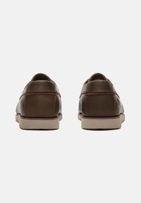 Bruna läderskor med en slät finish, rund tå och en beige gummisula. Dekorativ sömnad och subtil logotyp på hälen.