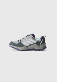 Gray and purple Adidas Terrex hiking shoe with black laces, textured sole, and light blue interior lining, side view on white background.