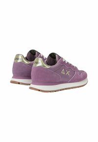 Sneaker in suede viola con una suola bianca, caratterizzate da un accento dorato sul tallone e lacci bianchi. Logo visibile sul retro.