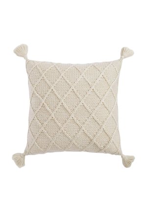 Square cream-colored knitted cushion with diamond pattern and tassels on each corner against a white background.