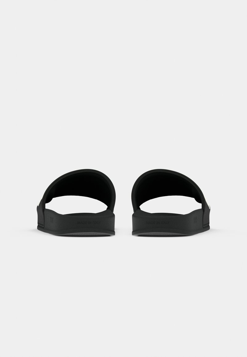 Schwarze Gummischlappen mit breiten Riemen, flachen Sohlen und dezentem Branding. Glatte Textur ohne zusätzliche Muster oder Akzente.