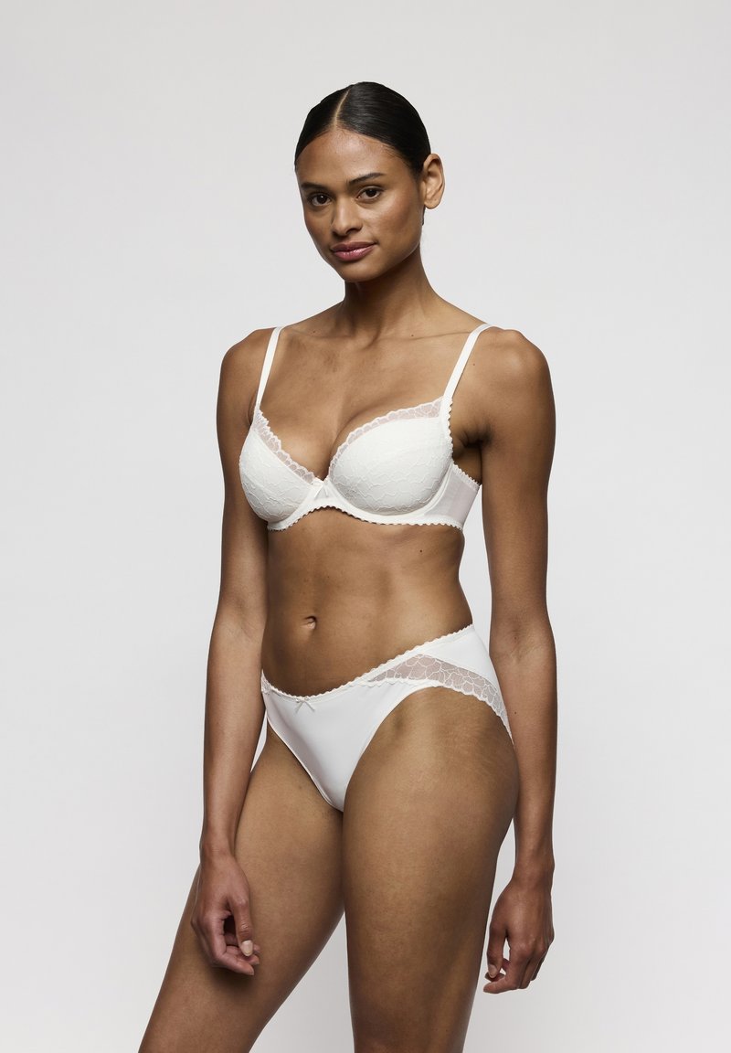 Conjunto de sujetador blanco y braga a juego con detalles de encaje, tejido suave, bordes ondulados y diseño estructurado. Adecuado para uso diario.