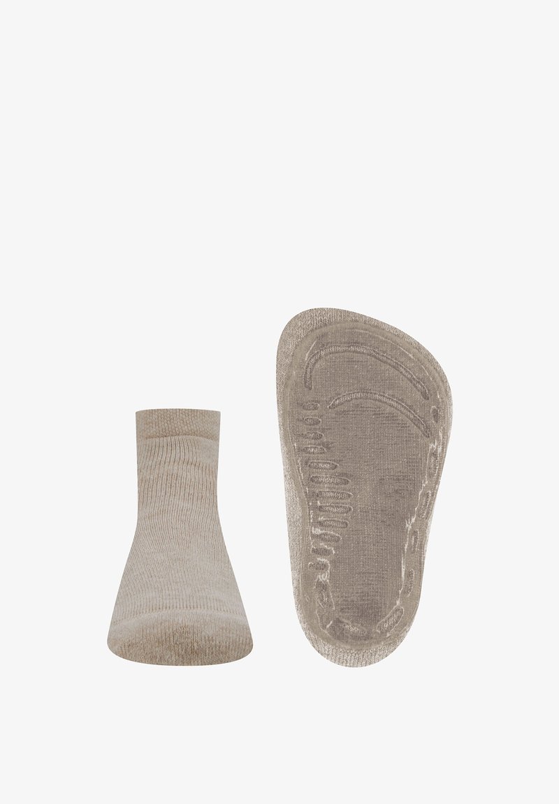Beżowa skarpetka sięgająca kostki z prążkowaną teksturą, elastycznym brzegiem i silikonowym uchwytem na podeszwie dla lepszej przyczepności. Krzywy kształt wspiera kontur stopy.