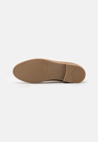 Suela de zapato marrón con superficie de goma texturizada. Presenta una punta redondeada y un ligero tacón. Marca visible en el lateral.